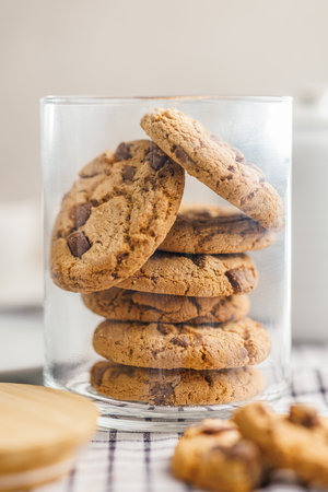 Sweet chocolate cookies in a jar on the checkered napkin.の写真素材