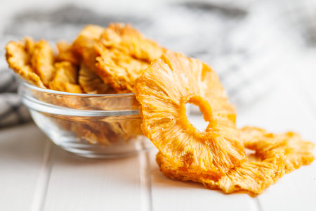 Dried pineapple rings on the white table.の写真素材