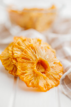 Dried pineapple rings on the white table.の写真素材