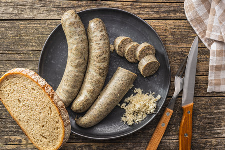 White pudding sausage. Pork product on plate on the wooden table. Top view.の写真素材