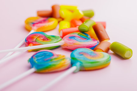 Heart shaped lollipop. Sweet candy on the pink background.の写真素材