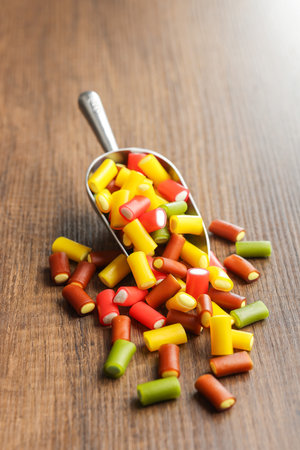 Colorful sweet jelly candies in scoop on the wooden table.の写真素材