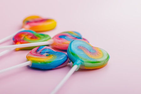 Heart shaped lollipop. Sweet candy on the pink background.の写真素材