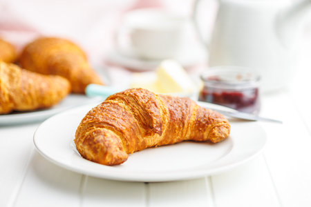 Baked tasty croissant on plate on the white table.の写真素材