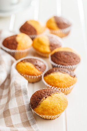 A variety of golden-brown muffins on a white table, inviting a taste.の写真素材