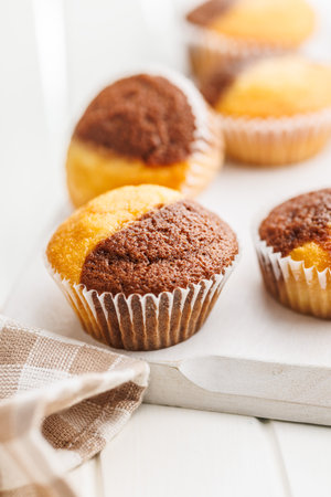 A variety of golden-brown muffins on a white table, inviting a taste.の写真素材