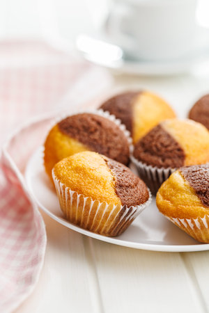 A variety of golden-brown muffins on a white table, inviting a taste.の写真素材