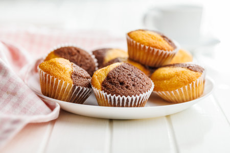 A variety of golden-brown muffins on a white table, inviting a taste.の写真素材