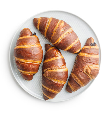 Freshly Baked Chocolate Croissants on Plate Isolated Against a White Backgroundの写真素材
