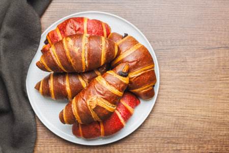Freshly Baked fruity and Chocolate Croissants on a plate on a kitchen table. Top view.の写真素材