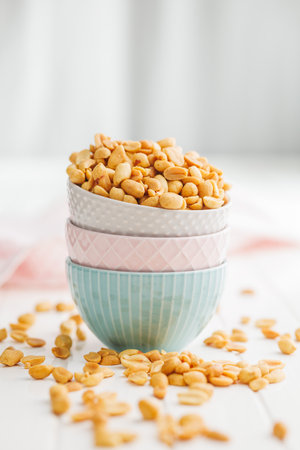 Salted roasted peanuts in a bowl on a kitchen tableの写真素材