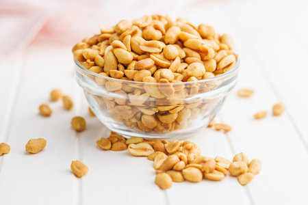 Salted roasted peanuts in a bowl on a kitchen tableの写真素材