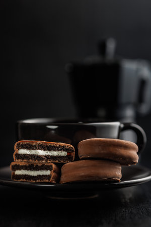 Close-Up View of Chocolate-Coated Sandwich Cookies on a Dark Backgroundの写真素材