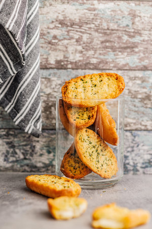 Garlic crisp bread Slices Topped With Herbs in a jar on a kitchen table.の写真素材