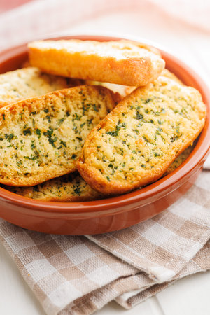 Garlic crisp bread Slices Topped With Herbs in a bowl.の写真素材