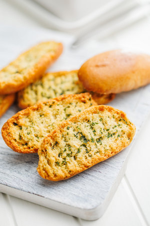 Garlic crisp bread Slices Topped With Herbs on a cutting board.の写真素材
