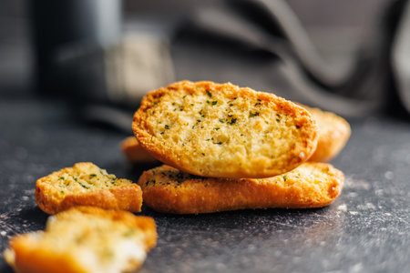 Garlic crisp bread Slices Topped With Herbs on a black table.の写真素材
