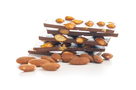 Broken chocolate bar with almonds isolated on a white background.の写真素材