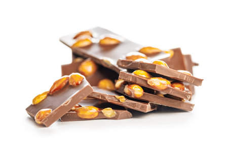 Broken chocolate bar with almonds isolated on a white background.の写真素材