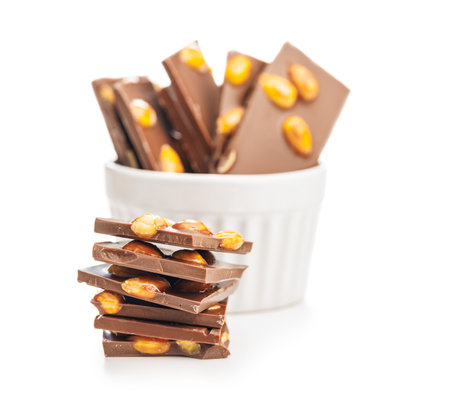 Broken chocolate bar with almonds isolated on a white background.の写真素材