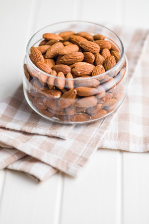 Peeled almond nuts in a jar on a kitchen table.の写真素材