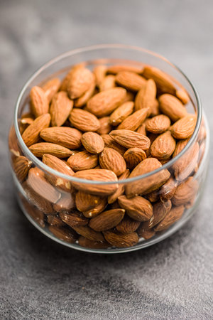Peeled almond nuts in a jar on a kitchen table.の写真素材