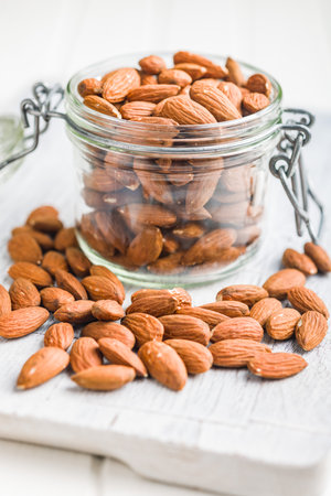 Peeled almond nuts in a jar on a kitchen table.の写真素材