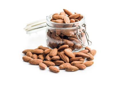 Peeled almond nuts in jar isolated on a white background.の写真素材