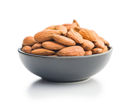 Peeled almond nuts in bowl isolated on a white background.の写真素材