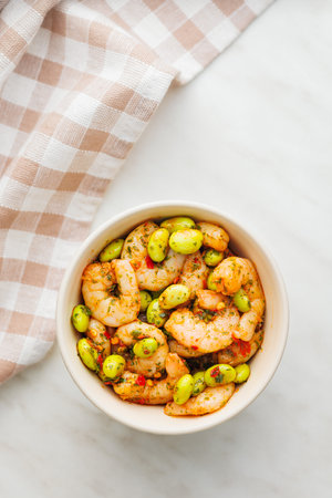 Fresh salad with shrimps and edamame soybeans in a bowl on a kitchen table. Top view.の写真素材