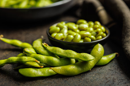 Green edamame pods. Fresh soybeans on a black table.の写真素材