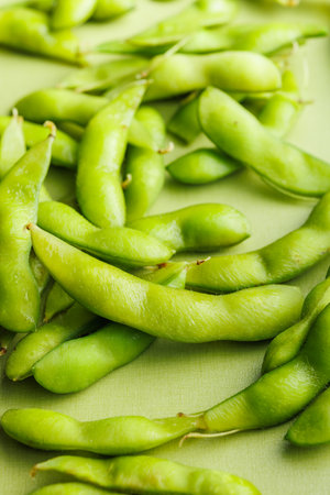 Green edamame pods. Fresh soybeans on a green table.の写真素材