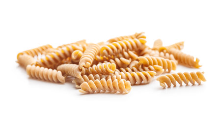 Uncooked whole grain pasta isolated on a white background. Raw fusilli.の写真素材