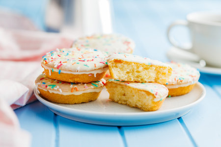Sweet dessert with sugar coating on a plate on a blue table.の写真素材