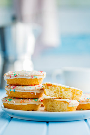 Sweet dessert with sugar coating on a plate on a blue table.の写真素材