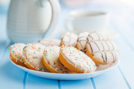 Sweet dessert with sugar coating on a plate on a blue table.の写真素材