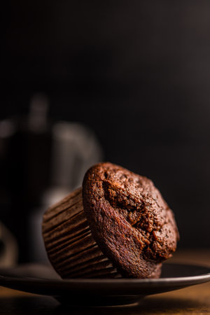 Sweet chocolate muffin cakes on a plate on a wooden table.の写真素材