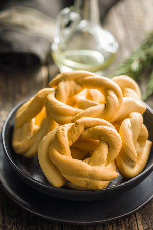 Ciambelle di sir. Crispy italian salted donuts on a plate on a wooden table.の写真素材