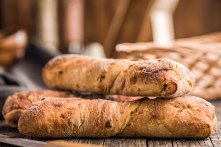 Crusty rustic baguette on a wooden table.の写真素材