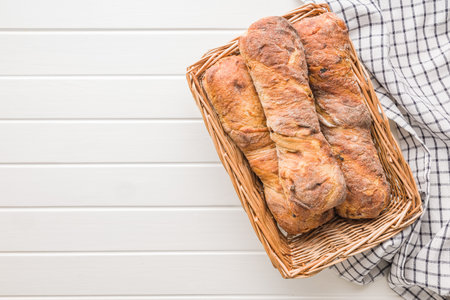 Crusty rustic baguette in basket on a white table. Top view.の写真素材