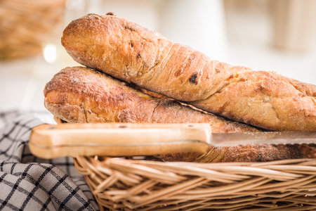 Crusty rustic baguette in basket on a white table.の写真素材