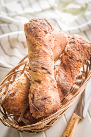 Crusty rustic baguette in basket on a white table.の写真素材
