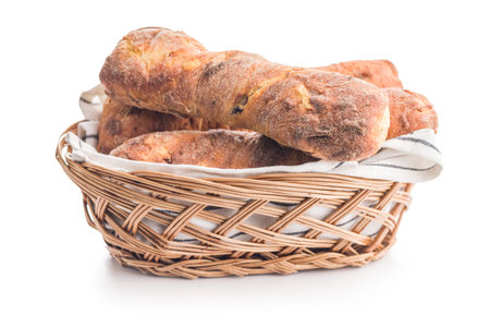 Crusty rustic baguette in basket isolated on a white table.の写真素材
