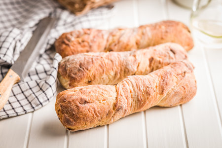 Crusty rustic baguette on a white table.の写真素材