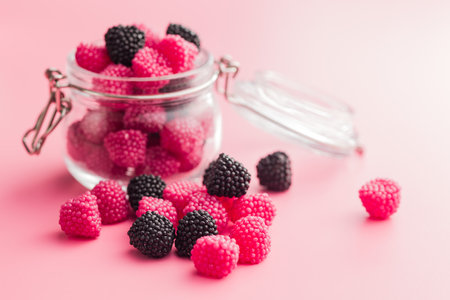 Sweet jelly candies in a jar on a pink background.の写真素材
