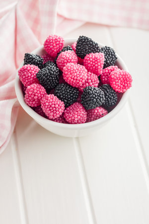 Sweet jelly candies in a bowl on a white table.の写真素材