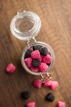 Sweet jelly candies in a jar on a wooden table. Top view.の写真素材