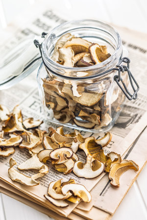 Dried mushrooms. Sliced boletus in a jar on a white table.の写真素材