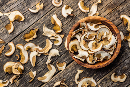 Dried porcini mushrooms. Sliced boletus in a bowl on a wooden table. Top view.の写真素材
