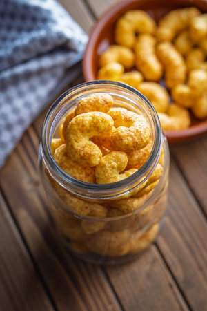Puffed crispy Peanut flips in a jar on a wooden table.の写真素材